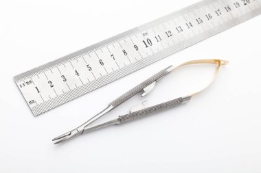 Çelik cerrahi aletler ve laboratuvar ekipmanları beyaz arka planda izole edilmiş. Profesyonel klinik aletleri. Tıbbi, cerrahi, ambulans ve veteriner konsepti. Yumuşak seçici odaklı yakın plan