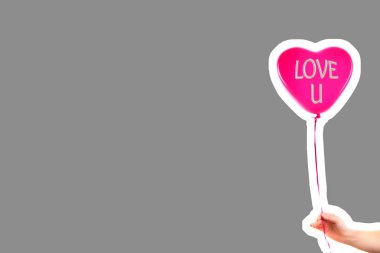 Kadın eli kırmızı kauçuk, şişme kalp şeklinde balon tutuyor. Aşk, ilişki, sevgililer günü ve doğum günü kutlaması konsepti. Boş kopya alanı olan dergi tarzı moda kolajı