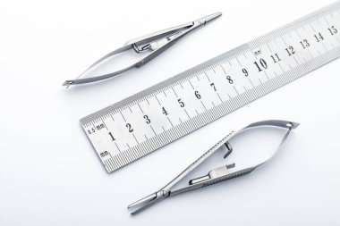 Çelik cerrahi aletler ve laboratuvar ekipmanları beyaz arka planda izole edilmiş. Profesyonel klinik aletleri. Tıbbi, cerrahi, ambulans ve veteriner konsepti. Yumuşak seçici odaklı yakın plan