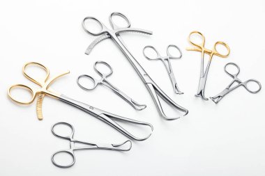 Çelik cerrahi aletler ve laboratuvar ekipmanları beyaz arka planda izole edilmiş. Profesyonel klinik aletleri. Tıbbi, cerrahi, ambulans ve veteriner konsepti. Yumuşak seçici odaklı yakın plan