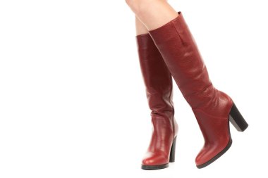 Bayan giysi ayakkabısı. Uzun ince dişinin bacakları yüksek topuklu uzun çizmeler giyer. Fotokopi alanı olan moda modeli. Klasik ve günlük kıyafet konsepti. Ayrıntılı yakın çekim stüdyo çekimi beyaz arkaplanda izole edildi