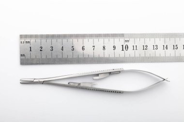 Çelik cerrahi aletler ve laboratuvar ekipmanları beyaz arka planda izole edilmiş. Profesyonel klinik aletleri. Tıbbi, cerrahi, ambulans ve veteriner konsepti. Yumuşak seçici odaklı yakın plan