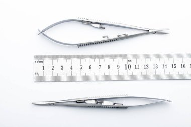 Çelik cerrahi aletler ve laboratuvar ekipmanları beyaz arka planda izole edilmiş. Profesyonel klinik aletleri. Tıbbi, cerrahi, ambulans ve veteriner konsepti. Yumuşak seçici odaklı yakın plan