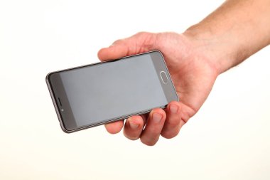 İnsan eli, avucunda boş bir krom ekran olan modern bir akıllı telefonu tutar. Teknoloji ve reklam kavramı. Ayrıntılı yakın çekim stüdyo çekimi soyut beyaz arka planda izole