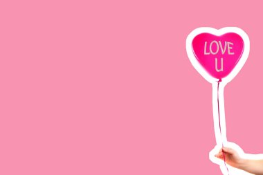 Kadın eli kırmızı kauçuk, şişme kalp şeklinde balon tutuyor. Aşk, ilişki, sevgililer günü ve doğum günü kutlaması konsepti. Boş kopya alanı olan dergi tarzı moda kolajı