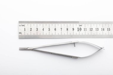 Çelik cerrahi aletler ve laboratuvar ekipmanları beyaz arka planda izole edilmiş. Profesyonel klinik aletleri. Tıbbi, cerrahi, ambulans ve veteriner konsepti. Yumuşak seçici odaklı yakın plan