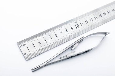 Çelik cerrahi aletler ve laboratuvar ekipmanları beyaz arka planda izole edilmiş. Profesyonel klinik aletleri. Tıbbi, cerrahi, ambulans ve veteriner konsepti. Yumuşak seçici odaklı yakın plan