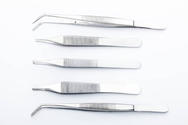 Çelik cerrahi aletler ve laboratuvar ekipmanları beyaz arka planda izole edilmiş. Profesyonel klinik aletleri. Tıbbi, cerrahi, ambulans ve veteriner konsepti. Yumuşak seçici odaklı yakın plan