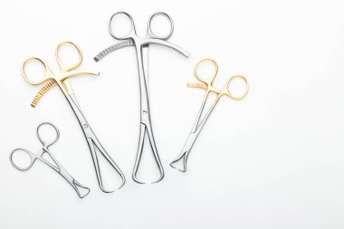 Çelik cerrahi aletler ve laboratuvar ekipmanları beyaz arka planda izole edilmiş. Profesyonel klinik aletleri. Tıbbi, cerrahi, ambulans ve veteriner konsepti. Yumuşak seçici odaklı yakın plan