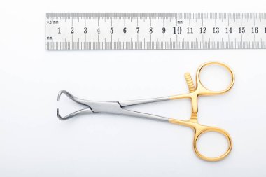 Çelik cerrahi aletler ve laboratuvar ekipmanları beyaz arka planda izole edilmiş. Profesyonel klinik aletleri. Tıbbi, cerrahi, ambulans ve veteriner konsepti. Yumuşak seçici odaklı yakın plan