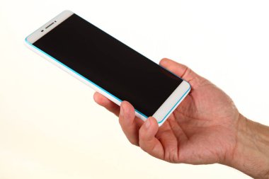 İnsan eli, avucunda boş bir krom ekran olan modern bir akıllı telefonu tutar. Teknoloji ve reklam kavramı. Ayrıntılı yakın çekim stüdyo çekimi soyut beyaz arka planda izole