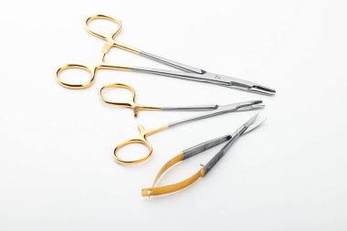 Çelik cerrahi aletler ve laboratuvar ekipmanları beyaz arka planda izole edilmiş. Profesyonel klinik aletleri. Tıbbi, cerrahi, ambulans ve veteriner konsepti. Yumuşak seçici odaklı yakın plan