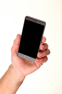 İnsan eli, avucunda boş bir krom ekran olan modern bir akıllı telefonu tutar. Teknoloji ve reklam kavramı. Ayrıntılı yakın çekim stüdyo çekimi soyut beyaz arka planda izole