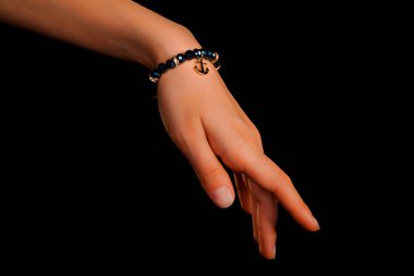 Güzel bir el yapımı mücevher bileziği. Renkli parlak boncuklar ve nötr manikürlü gevşek bir kadın bileği. Moda ve el işi aksesuarları. Yumuşak seçici odaklı yakın plan