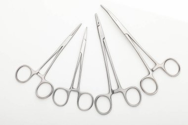 Çelik cerrahi aletler ve laboratuvar ekipmanları beyaz arka planda izole edilmiş. Profesyonel klinik aletleri. Tıbbi, cerrahi, ambulans ve veteriner konsepti. Yumuşak seçici odaklı yakın plan