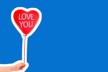 Kadın eli kırmızı kauçuk, şişme kalp şeklinde balon tutuyor. Aşk, ilişki, sevgililer günü ve doğum günü kutlaması konsepti. Boş kopya alanı olan dergi tarzı moda kolajı