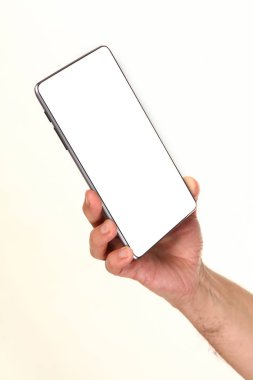 İnsan eli, avucunda boş bir krom ekran olan modern bir akıllı telefonu tutar. Teknoloji ve reklam kavramı. Ayrıntılı yakın çekim stüdyo çekimi soyut beyaz arka planda izole