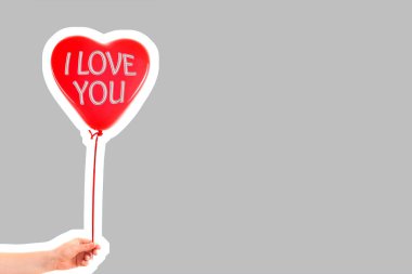 Kadın eli kırmızı kauçuk, şişme kalp şeklinde balon tutuyor. Aşk, ilişki, sevgililer günü ve doğum günü kutlaması konsepti. Boş kopya alanı olan dergi tarzı moda kolajı