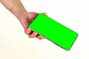 İnsan eli, avucunda boş bir krom ekran olan modern bir akıllı telefonu tutar. Teknoloji ve reklam kavramı. Ayrıntılı yakın çekim stüdyo çekimi soyut beyaz arka planda izole