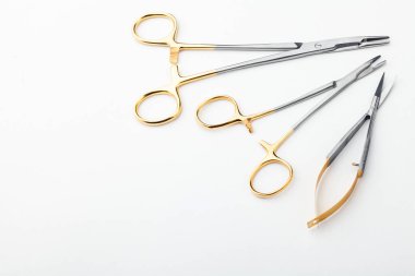 Çelik cerrahi aletler ve laboratuvar ekipmanları beyaz arka planda izole edilmiş. Profesyonel klinik aletleri. Tıbbi, cerrahi, ambulans ve veteriner konsepti. Yumuşak seçici odaklı yakın plan