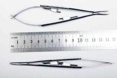 Çelik cerrahi aletler ve laboratuvar ekipmanları beyaz arka planda izole edilmiş. Profesyonel klinik aletleri. Tıbbi, cerrahi, ambulans ve veteriner konsepti. Yumuşak seçici odaklı yakın plan