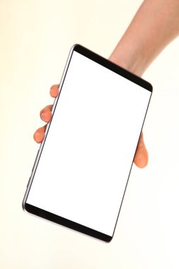 İnsan eli, avucunda boş bir krom ekran olan modern bir akıllı telefonu tutar. Teknoloji ve reklam kavramı. Ayrıntılı yakın çekim stüdyo çekimi soyut beyaz arka planda izole