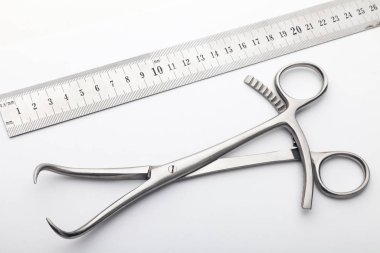 Çelik cerrahi aletler ve laboratuvar ekipmanları beyaz arka planda izole edilmiş. Profesyonel klinik aletleri. Tıbbi, cerrahi, ambulans ve veteriner konsepti. Yumuşak seçici odaklı yakın plan