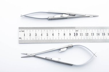 Çelik cerrahi aletler ve laboratuvar ekipmanları beyaz arka planda izole edilmiş. Profesyonel klinik aletleri. Tıbbi, cerrahi, ambulans ve veteriner konsepti. Yumuşak seçici odaklı yakın plan