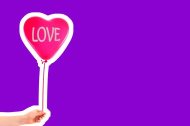 Kadın eli kırmızı kauçuk, şişme kalp şeklinde balon tutuyor. Aşk, ilişki, sevgililer günü ve doğum günü kutlaması konsepti. Boş kopya alanı olan dergi tarzı moda kolajı