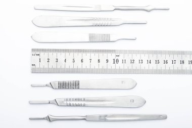 Çelik cerrahi aletler ve laboratuvar ekipmanları beyaz arka planda izole edilmiş. Profesyonel klinik aletleri. Tıbbi, cerrahi, ambulans ve veteriner konsepti. Yumuşak seçici odaklı yakın plan