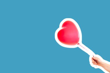 Kadın eli kırmızı kauçuk, şişme kalp şeklinde balon tutuyor. Aşk, ilişki, sevgililer günü ve doğum günü kutlaması konsepti. Boş kopya alanı olan dergi tarzı moda kolajı