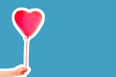 Kadın eli kırmızı kauçuk, şişme kalp şeklinde balon tutuyor. Aşk, ilişki, sevgililer günü ve doğum günü kutlaması konsepti. Boş kopya alanı olan dergi tarzı moda kolajı