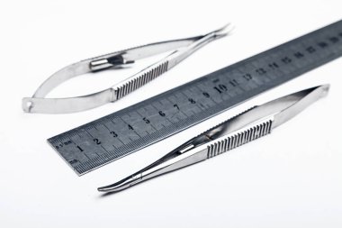 Çelik cerrahi aletler ve laboratuvar ekipmanları beyaz arka planda izole edilmiş. Profesyonel klinik aletleri. Tıbbi, cerrahi, ambulans ve veteriner konsepti. Yumuşak seçici odaklı yakın plan