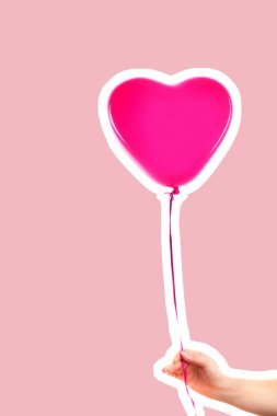 Kadın eli pembe kauçuk, şişme kalp şeklinde balon tutuyor. Aşk, ilişki, sevgililer günü ve doğum günü kutlaması konsepti. Boş kopya alanı olan dergi tarzı moda kolajı