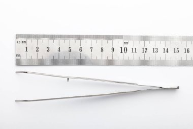 Çelik cerrahi aletler ve laboratuvar ekipmanları beyaz arka planda izole edilmiş. Profesyonel klinik aletleri. Tıbbi, cerrahi, ambulans ve veteriner konsepti. Yumuşak seçici odaklı yakın plan