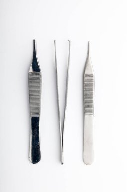 Çelik cerrahi aletler ve laboratuvar ekipmanları beyaz arka planda izole edilmiş. Profesyonel klinik aletleri. Tıbbi, cerrahi, ambulans ve veteriner konsepti. Yumuşak seçici odaklı yakın plan