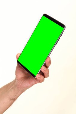 İnsan eli, avucunda boş bir krom ekran olan modern bir akıllı telefonu tutar. Teknoloji ve reklam kavramı. Ayrıntılı yakın çekim stüdyo çekimi soyut beyaz arka planda izole