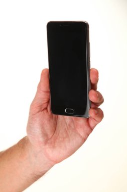 İnsan eli, avucunda boş bir krom ekran olan modern bir akıllı telefonu tutar. Teknoloji ve reklam kavramı. Ayrıntılı yakın çekim stüdyo çekimi soyut beyaz arka planda izole