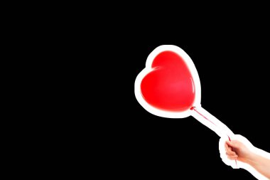 Kadın eli kırmızı kauçuk, şişme kalp şeklinde balon tutuyor. Aşk, ilişki, sevgililer günü ve doğum günü kutlaması konsepti. Boş kopya alanı olan dergi tarzı moda kolajı