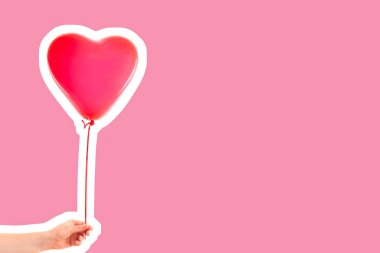 Kadın eli kırmızı kauçuk, şişme kalp şeklinde balon tutuyor. Aşk, ilişki, sevgililer günü ve doğum günü kutlaması konsepti. Boş kopya alanı olan dergi tarzı moda kolajı