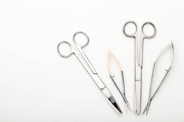 Çelik cerrahi aletler ve laboratuvar ekipmanları beyaz arka planda izole edilmiş. Profesyonel klinik aletleri. Tıbbi, cerrahi, ambulans ve veteriner konsepti. Yumuşak seçici odaklı yakın plan