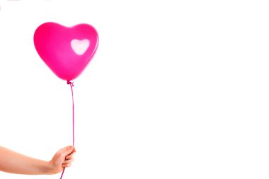 Kadın eli pembe kauçuk, şişme kalp şeklinde balon tutuyor. Aşk, ilişki, sevgililer günü ve doğum günü kutlaması konsepti. Stüdyo görüntüsü boş kopya alanı olan bulanık bir arkaplan üzerinde