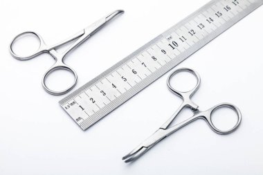 Çelik cerrahi aletler ve laboratuvar ekipmanları beyaz arka planda izole edilmiş. Profesyonel klinik aletleri. Tıbbi, cerrahi, ambulans ve veteriner konsepti. Yumuşak seçici odaklı yakın plan