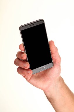 İnsan eli, avucunda boş bir krom ekran olan modern bir akıllı telefonu tutar. Teknoloji ve reklam kavramı. Ayrıntılı yakın çekim stüdyo çekimi soyut beyaz arka planda izole
