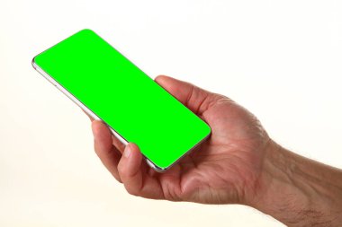 İnsan eli, avucunda boş bir krom ekran olan modern bir akıllı telefonu tutar. Teknoloji ve reklam kavramı. Ayrıntılı yakın çekim stüdyo çekimi soyut beyaz arka planda izole