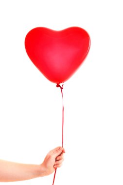 Kadın eli kırmızı kauçuk, şişme kalp şeklinde balon tutuyor. Aşk, ilişki, sevgililer günü ve doğum günü kutlaması konsepti. Stüdyo görüntüsü boş kopya alanı olan bulanık bir arkaplan üzerinde