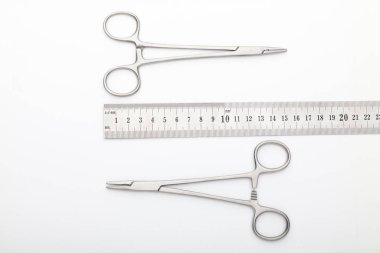 Çelik cerrahi aletler ve laboratuvar ekipmanları beyaz arka planda izole edilmiş. Profesyonel klinik aletleri. Tıbbi, cerrahi, ambulans ve veteriner konsepti. Yumuşak seçici odaklı yakın plan