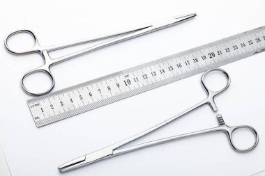 Çelik cerrahi aletler ve laboratuvar ekipmanları beyaz arka planda izole edilmiş. Profesyonel klinik aletleri. Tıbbi, cerrahi, ambulans ve veteriner konsepti. Yumuşak seçici odaklı yakın plan