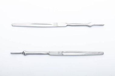 Çelik cerrahi aletler ve laboratuvar ekipmanları beyaz arka planda izole edilmiş. Profesyonel klinik aletleri. Tıbbi, cerrahi, ambulans ve veteriner konsepti. Yumuşak seçici odaklı yakın plan