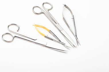 Çelik cerrahi aletler ve laboratuvar ekipmanları beyaz arka planda izole edilmiş. Profesyonel klinik aletleri. Tıbbi, cerrahi, ambulans ve veteriner konsepti. Yumuşak seçici odaklı yakın plan